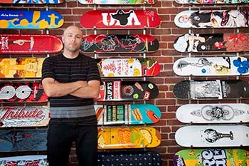 Owner of Atlas, a downtown business stands in front display in store.