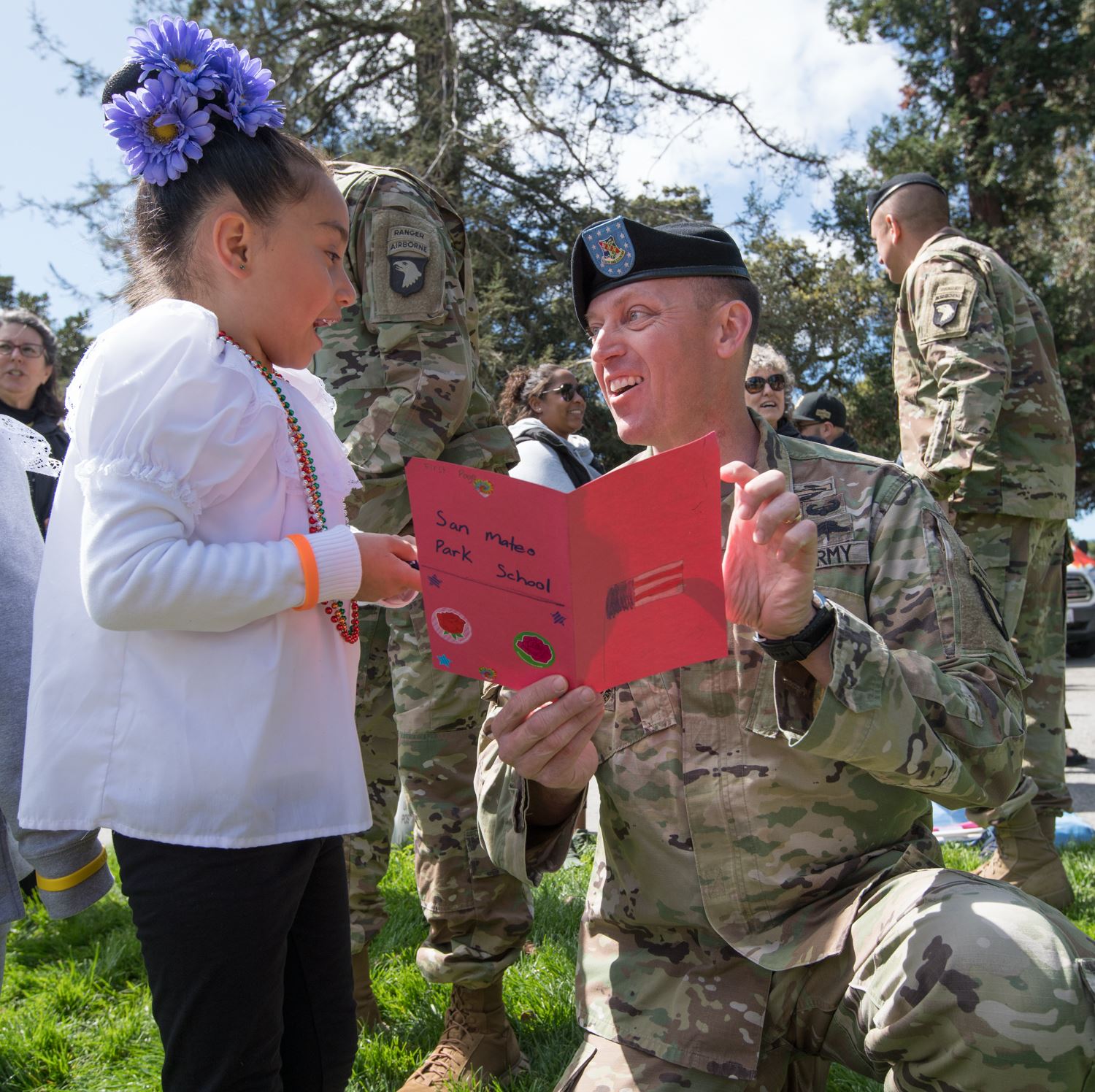 Girl gives soldier a card photo
